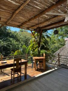 a wooden deck with a wooden table and chairs at Loft Amplio con Vista Natural en Mazunte in Mazunte