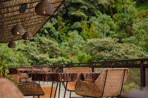 a table and chairs on a balcony with trees at Cannúa Lodge Hotel in Marinilla