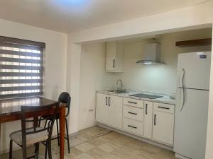 a kitchen with white cabinets and a white refrigerator at Casa 5 Centrica Super ubicada 3 camas queen in Hermosillo