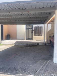 an empty parking lot with a gate in a building at Casa 5 Centrica Super ubicada 3 camas queen in Hermosillo