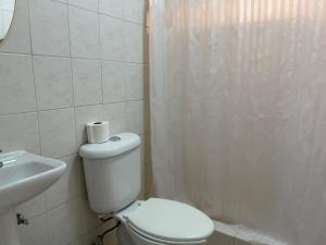 a white bathroom with a toilet and a sink at Casa 5 Centrica Super ubicada 3 camas queen in Hermosillo