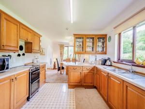 a large kitchen with wooden cabinets and appliances at Glenview in Appin +17 photos