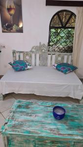 a bedroom with a bed with a blue bowl on the floor at Villa Tewa in Mtwapa