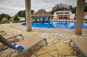 a swimming pool with two chairs and a resort at Hotel Real Tamasopo in Tamasopo