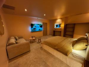 a bedroom with a large bed and a couch at ExSPArience Private Spa Suite in Poitiers