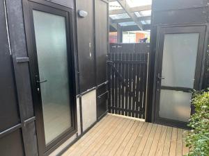 a hallway with two glass doors on a building at Myrtle St Guesthouse in Auckland +1 photo