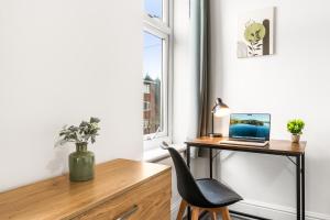 a desk with a laptop on it next to a window at Comfortable 4 Bed Home - Free Parking & Brand New Bathroom in Denton