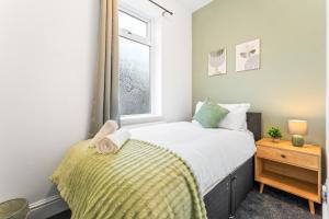 a small bedroom with a bed and a window at Comfortable 4 Bed Home - Free Parking & Brand New Bathroom in Denton