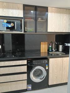 a kitchen with a washing machine and a microwave at scandic resort sea view balcony free wi fi in Hurghada
