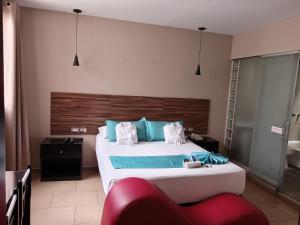 a bedroom with a large white bed with blue pillows at Hotel Lince in Lima