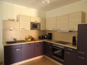 a kitchen with brown cabinets and a microwave at Casa Cavallo in Göhren-Lebbin