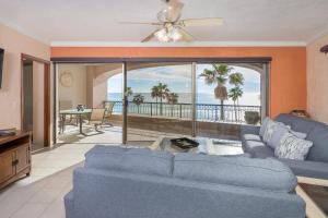 a living room with a blue couch and a view of the ocean at 3 Bedroom Beach Front at Sonoran Spa E410 in Puerto Peñasco