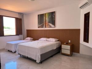 a bedroom with two beds and a window at Casa - Conceito in Bom Jesus da Lapa