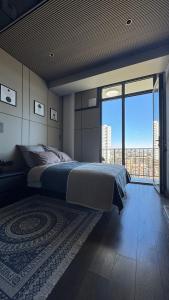 a bedroom with a large bed and a large window at Premium Smart Studio with River View in Tbilisi City