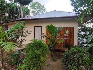 a cottage with a door and a bench in front of it at Koh tao two view in Ko Tao