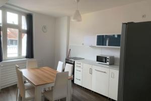 a kitchen with a wooden table and a kitchen with white cabinets at Sleek Apartment in Troisdorf in Troisdorf