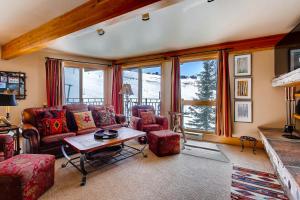 a living room with couches and a table and windows at Crested Butte Mountain Resort Properties by Vail Resorts in Crested Butte