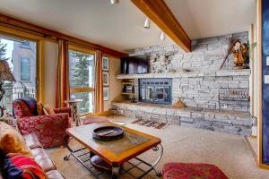 a living room with a large stone fireplace at Crested Butte Mountain Resort Properties by Vail Resorts in Crested Butte
