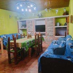 a dining room with a table and chairs and a tv at Don Mauricio y periquines in Robledillo