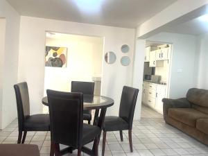 a dining room with a table and chairs and a kitchen at Casa 11 Centrica 3 camas queen in Hermosillo