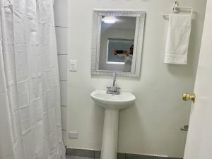 a man taking a picture of a bathroom with a sink at Casa 11 Centrica 3 camas queen in Hermosillo