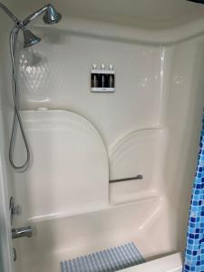 a white bath tub with a shower head and a sink at Serenity in Statesboro +2 photos