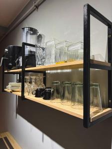 a shelf with glasses and other items on it at Home Tatuapé in São Paulo