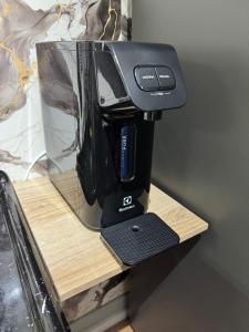a black coffee maker sitting on a wooden shelf at Home Tatuapé in São Paulo