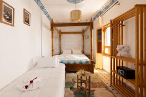 a small bedroom with a bed and a table at Riad Secret De Medina in Marrakesh +65 photos