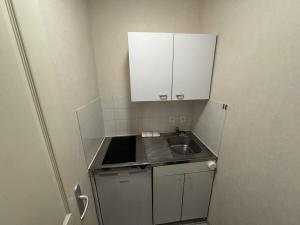 a small kitchen with a sink and a cabinet at Appartement centre Compiègne in Compiègne