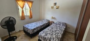 a bedroom with two beds and a window at Flor del Aromito in Alta Gracia