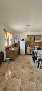 a kitchen with a table and a white refrigerator at Flor del Aromito in Alta Gracia
