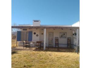 a house with a porch with chairs and tables at Casa Willy Pampa in Barreal