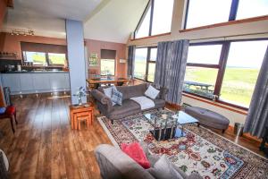 a living room with a couch and a table at Corncrake Cottage in Leverburgh