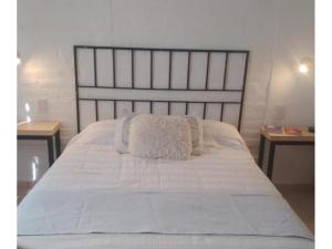a bed with white sheets and pillows on it at Casa Willy Pampa in Barreal