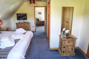 a bedroom with a bed and a table with towels at Corncrake Cottage in Leverburgh