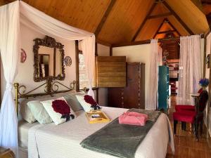 a bedroom with a bed with white sheets and a mirror at Divina Cabana - Lago Corumbá IV - Alexânia (GO) in Alexânia