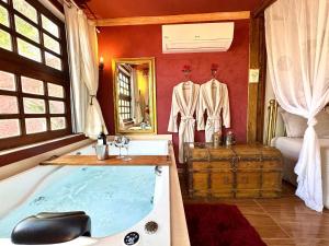 a bathroom with a bath tub and a bedroom at Divina Cabana - Lago Corumbá IV - Alexânia (GO) in Alexânia