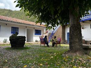 two people sitting in chairs under a tree at Casona Checacupe in Checacupe +23 photos
