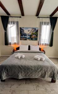 a bedroom with a large bed with two towels on it at Conacu Lacului Brebu in Brebu Mînăstirei