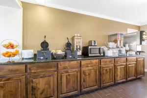 a large kitchen with wooden cabinets and a counter top at Super 8 by Wyndham Temple S General Bruce in Temple