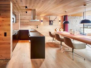 a kitchen and dining room with a table and chairs at Smaragdresort Gipfelstürmer in Brandberg +5 photos