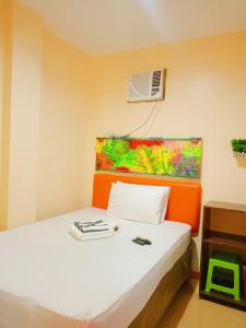 a bedroom with a bed with a air conditioner at Rafael Suites Inn in Mojon