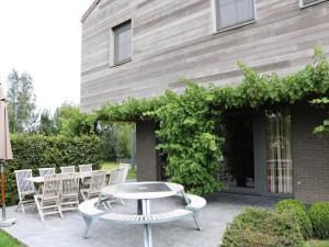 a patio with a table and chairs next to a building at Countryside holiday home in Gijverinkhove