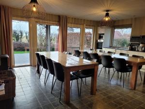 a kitchen with a large dining room with tables and chairs at Countryside holiday home in Gijverinkhove