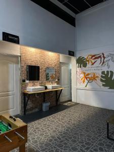 a bathroom with two sinks and a tv on the wall at Asha Hostel in Fortuna