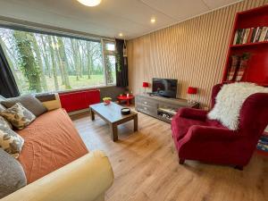 a living room with a couch and a tv at Berghuisje in Uden