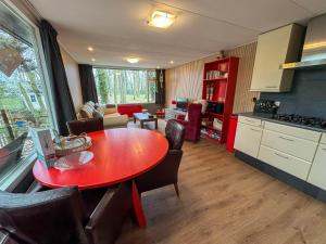 a kitchen and dining room with a red table at Berghuisje in Uden