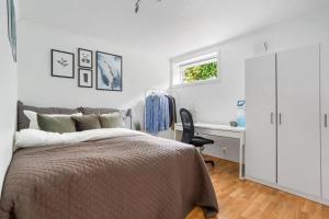 a bedroom with a bed and a desk and a window at Central 4 room apartment in Bergen
