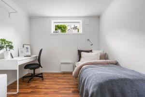 a white bedroom with a bed and a desk at Central 4 room apartment in Bergen